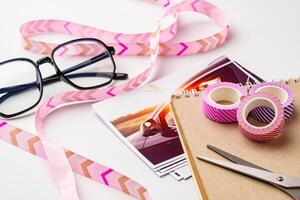 Crafting session with colorful ribbons, washi tape, and printed photos on a creative workspace