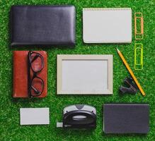 Office supplies arranged on green grass background creating a vibrant workspace scene photo