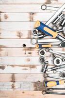 Tools arranged neatly on wooden surface, showing variety and readiness for use in mechanical work or repairs photo