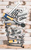 Collection of various hand tools arranged on a wooden surface for mechanics and DIY enthusiasts photo