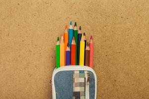 Colorful pencils neatly organized in a pencil case on a textured background photo