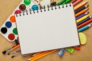Art supplies arranged on a creative workspace with a blank notebook waiting for inspiration in a colorful setup photo