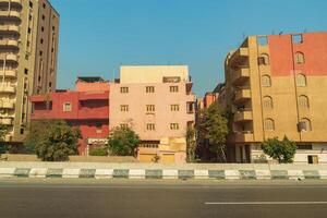 Vibrant buildings along a busy street in Cairo showcasing local architecture under a clear sky photo