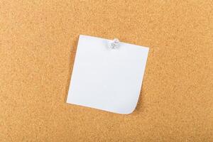 Blank sticky note pinned on a corkboard for reminders or messages in an organized workspace setting photo