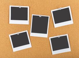 Collection of empty photo frames pinned on a cork board for creative projects or memory displays