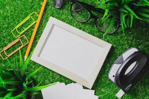 Creative workspace set up with stationery, a picture frame, and greenery in a vibrant environment photo