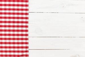Red and white checkered tablecloth placed on a clean wooden table with rustic finish for a cozy dining experience photo