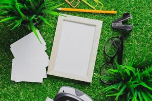Exploring creativity with an empty frame, office supplies, and greenery on a vibrant workspace photo