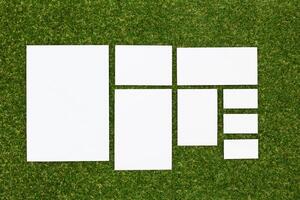 Multiple blank sheets arranged on grass for creative projects, design ideas, or presentations in a natural setting photo