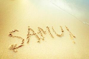 Message written in sand on a warm beach, capturing a personal moment during a sunny day by the ocean photo
