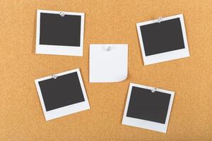 Collection of blank polaroids on cork board with a single sticky note placed in the center photo