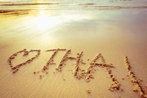 Message of love written in sand at sunset on a serene beach photo