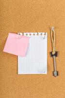 Document holder with a note and key on a cork bulletin board photo