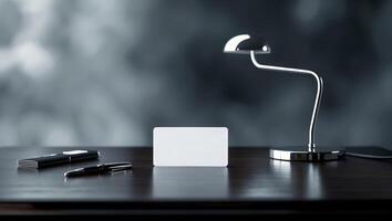 Elegant workspace with a sleek lamp, blank card, and pen on a modern wooden table in soft focus background photo