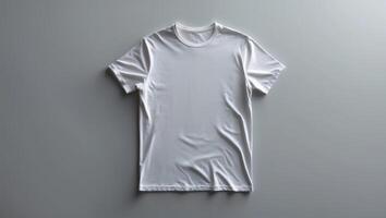 Plain white t-shirt displayed on a gray surface with soft lighting photo