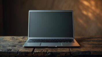 Laptop on an old wooden table in a warm, softly lit room with natural textures and shadows creating a cozy atmosphere photo