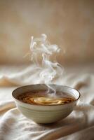 Warm bowl of steaming noodles placed on a soft textured surface welcoming colder seasons photo