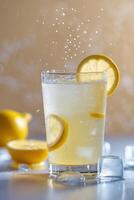 Refreshing lemon drink with ice and splashes in a bright setting during summer photo