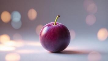 Fresh purple plum with dewdrops on a smooth surface illuminated by soft bokeh lights in the background photo
