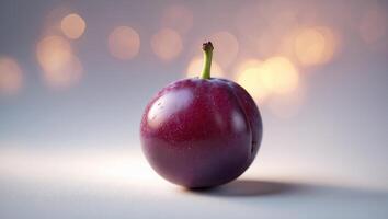 Fresh purple plum with dew droplets and soft bokeh background creates a serene and appetizing atmosphere photo