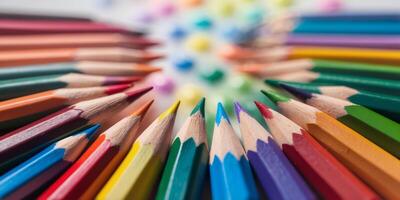 Colorful collection of sharpened pencils arranged in a circular pattern on a textured surface photo