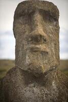 A statue of a man with a face on the side of a hill photo