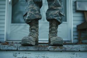 A soldier's boots standing on the porch of a house photo