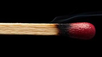 A matchstick with a red tip and black background photo