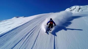 A person skiing down a snow covered mountain photo