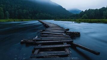 A wooden bridge crosses over a river in the middle of a forest photo