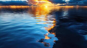 Sunset over the ocean with clouds reflected in the water photo