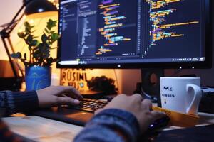 A person is working on a computer with a coffee mug in front of it photo