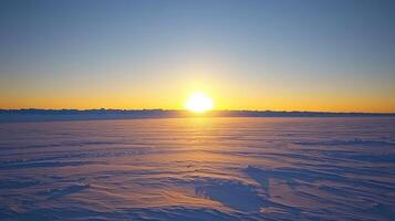 The sun is setting over a snowy field photo