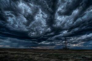 A stormy sky with dark clouds and a tall power line photo