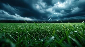 A dark stormy sky with lightning and green grass photo