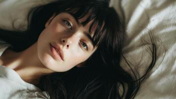 A woman laying on a bed with her eyes closed photo