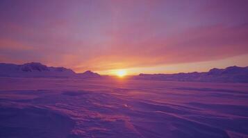 The sun sets over a snowy landscape photo