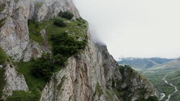 A rocky mountain slope overgrown with greenery, close-up. mountain valley with a river and fields in the lowland. photo