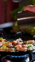 add black pepper to the shrimp Seafood meal recipe. Seasoning and spicing food. Chef adding pepper to shrimp in frying pan video