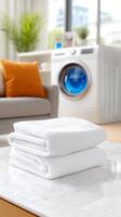 White towels on a table in front of a washing machine photo