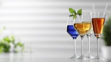 Three glasses with different colored drinks on a table photo