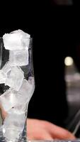 ice in a cocktail glass ice cubes in empty glass. Ice Cubes falling down in empty transparent glass. Make a fresh drink. Footage b roll scene 4k. Slow motion. video