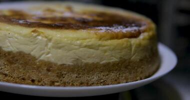 Basque burnt cheesecake on wooden table in baking room. video