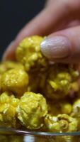 caramel popcorn Macro view how woman's hand takes popcorn. Caramel popcorns in the bowl. Probe lens. video