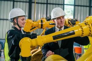 Collaboration between engineers and business professionals in a robotics facility during daylight photo