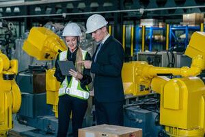 Engineers discussing project plans in a high-tech manufacturing facility during work hours photo