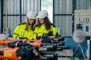 Two engineers collaborating on robotic technology in a modern factory setting during daylight hours photo