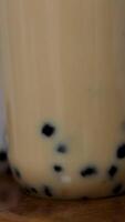 Buble Tea Boba or tapioca pearls is taiwan bubble milk tea in plastic cup with brown sugar flavor on texture background, summers refreshment. video
