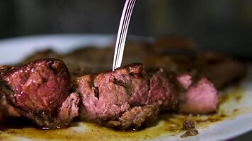 grilled meat shot of a juicy freshly grilled steak straight from the grid being cut with fork and knife on kitxhen table 0 food and drink 4k footage video