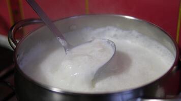 boil milk and flowed away. The boiling milk flows from the pan to the gas stove. The cow's milk boils in a saucepan and flows out.milk escaped video